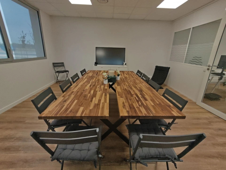 Salle de réunion équipée avec grande table en bois du coworking Porte des Pyrénées à Muret
