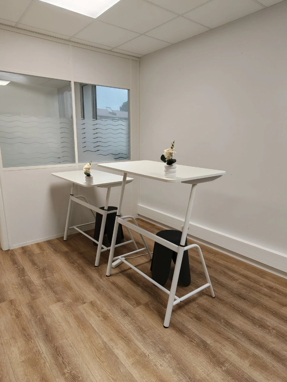 Salle de formation lumineuse du coworking Porte des Pyrénées à Muret, tables blanches et parquet